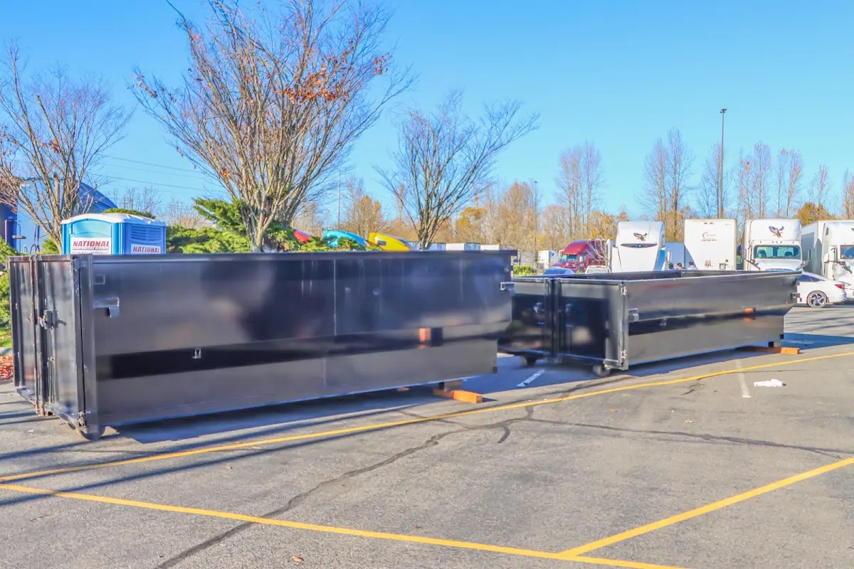 Professional dumpster rental service with roll-off container on residential driveway in West Greenwich